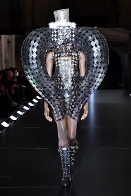 A model wearing a silver costume-dress with tube elements an a hat by Noir Kei Ninomiya