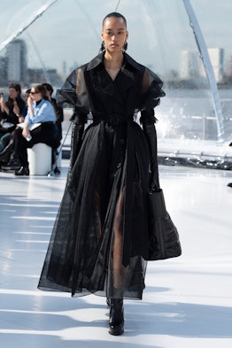 A model in a black organza coat and gloves at the Alexander McQueen spring 2023 fashion show