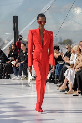 A model in a red suit and shoes at the Alexander McQueen spring 2023 fashion show
