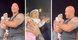 The Rock held the baby gently when he was passed the infant during a press event. 