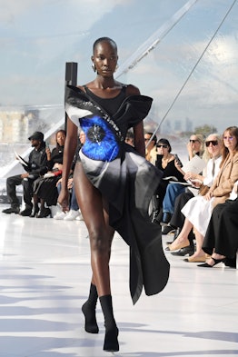A model in a black dress with a blue eye print at the Alexander McQueen spring 2023 fashion show