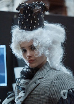 A model wearing a black-and-white blazer, a white wig and a black hat by Noir Kei Ninomiya