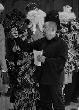 Noir Kei Ninomiya behind the scenes adjust the clothes on a model