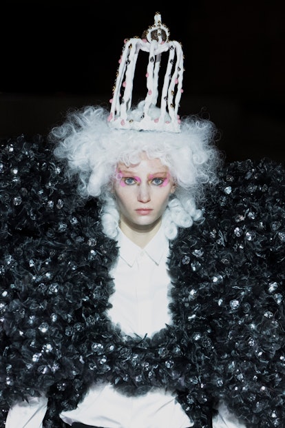 A model wearing a large 3D print puffer jacket, a white with, and a white crown by Noir Kei Ninomiya