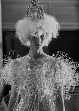 A model wearing a dress with 3D floral elements and fringe by Noir Kei Ninomiya