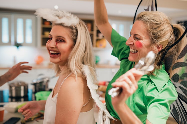 Young woman with mom sprinkling fairy dust on her on Halloween.