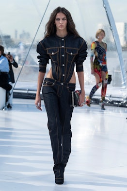 A model in a black denim jumpsuit with cut-outs at the Alexander McQueen spring 2023 fashion show