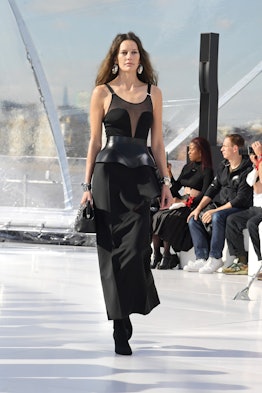 A model in a black dress and a bag at the Alexander McQueen spring 2023 fashion show
