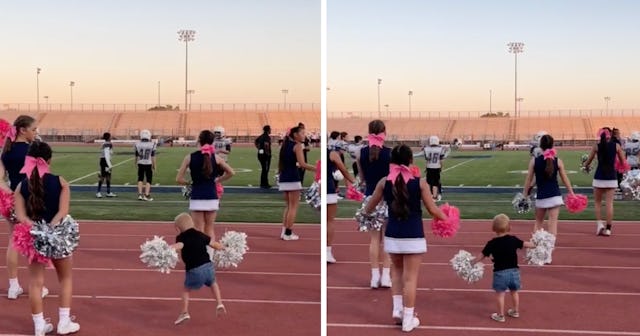 A two-year-old boy blends right in during a cheerleading routine.