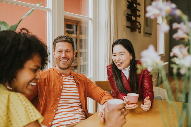 A young man sitting and having fun with two young ladies symbolizing micro-cheating