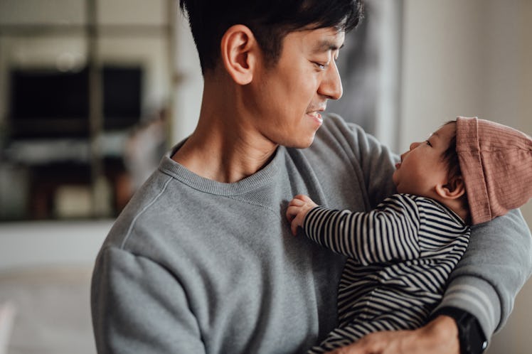 A dad holds a baby.