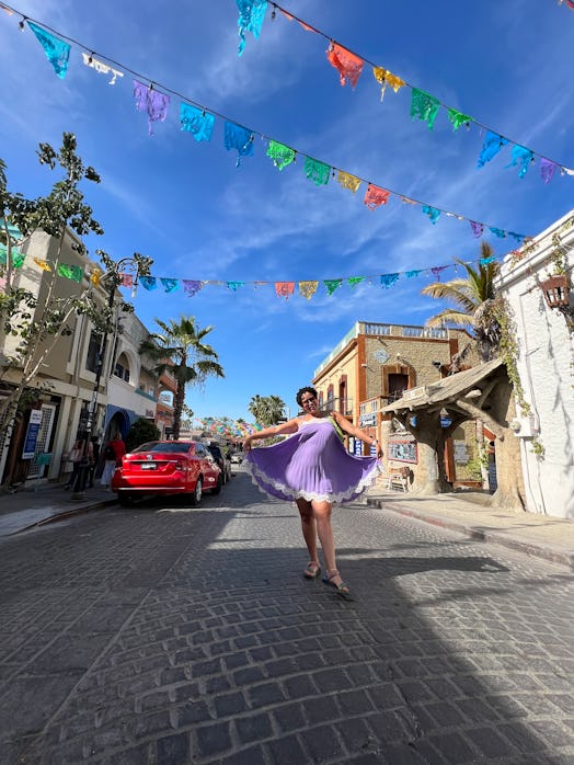 Natasha March posing in a purple dress in Cabo