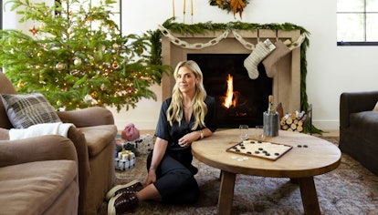 Amber Lewis in a living room with a fireplace and her first-ever holiday decor collab pieces
