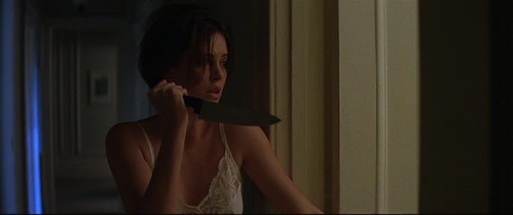 Charlize theron as Mary Ann holding a knife in the movie The Devil's Advocate