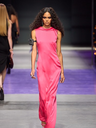 a model wears a pink dress on the versace catwalk 