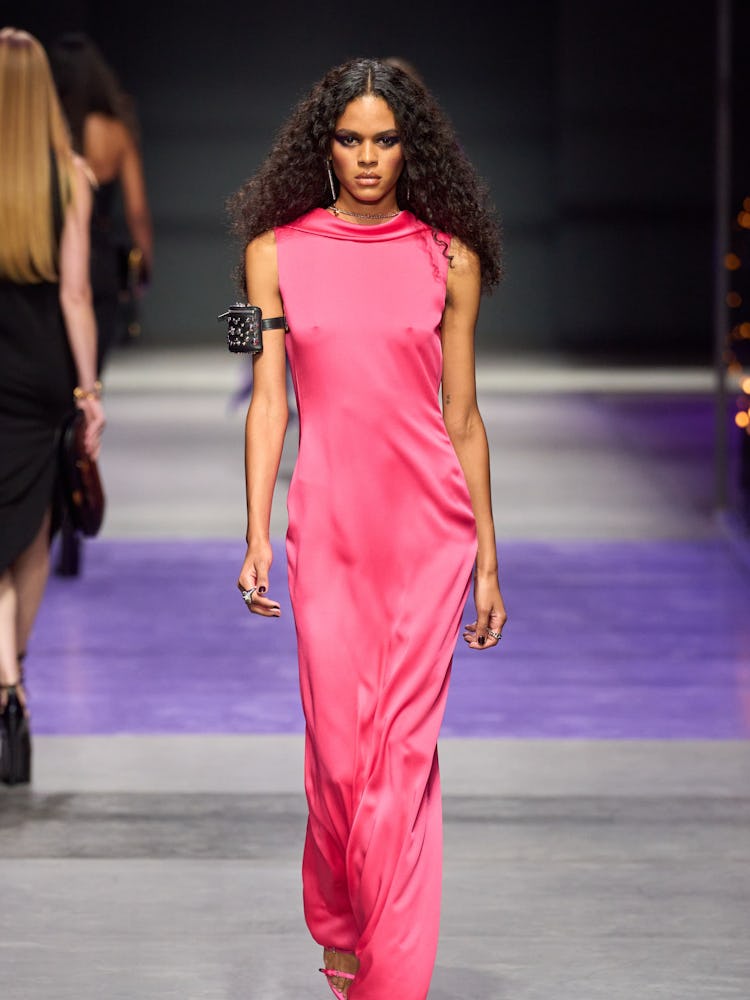 a model wears a pink dress on the versace runway 