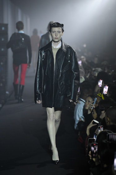 A model walking in a black leather jacket at the Raf Simons spring 2023 runway