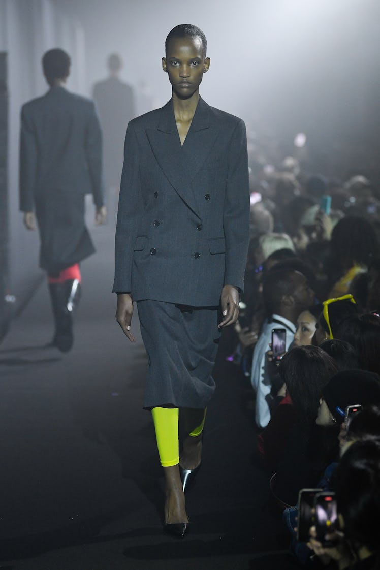 A model walking in a black blazer and black pants at the Raf Simons spring 2023 Runway