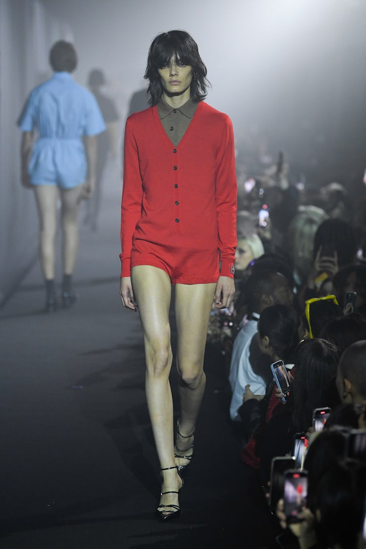 A model walking in a red mini dress at the Raf Simons spring 2023 runway