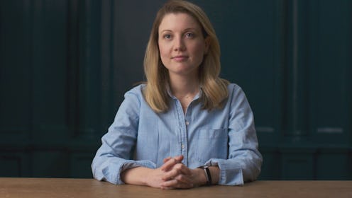 NXIVM Member Nicki Clyne sitting in a light blue shirt at a table