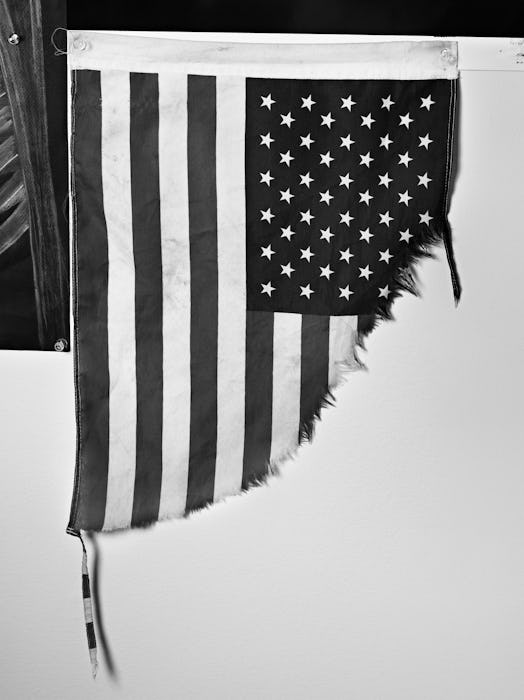 A black and white photo of a torn American flag