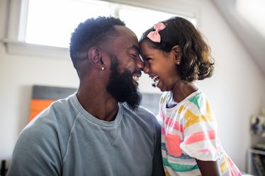 A father and a daughter leaned on each other's forehead smiling