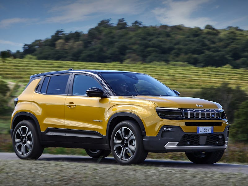 A yellow Jeep Avenger electric SUV parked in nature