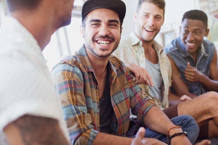 Four male friends sitting and laughing together