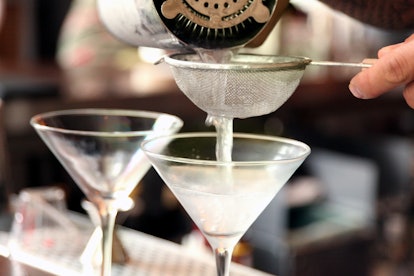A gin being poured in a glass for martini