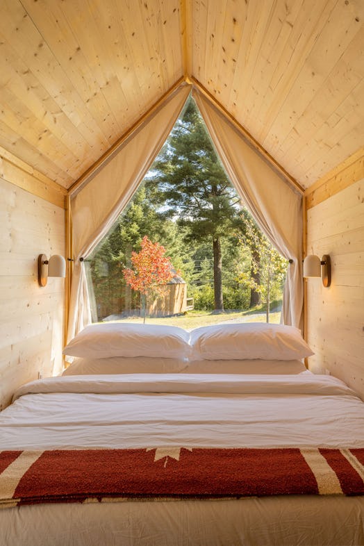A bedroom with a large window at Eastwind Lake Placid for the foliage views 