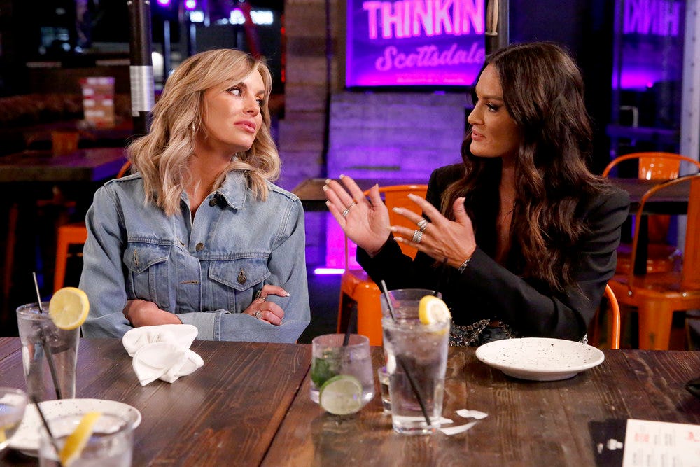 Lisa Barlow talking to Whitney Rose over drinks, gesturing with her hands. 