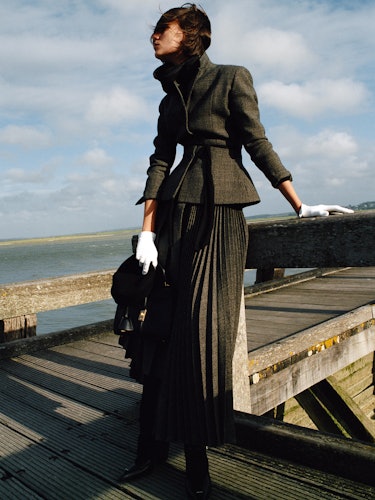 Medeiros wears a jacket, skirt, scarf, hat, white gloves; bag and shoes.