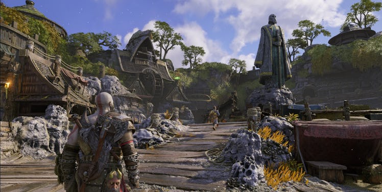 Kratos arriving at a large statue across a bridge in God of War: Ragnarök