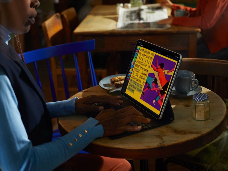 Person using Apple's M2 iPad, reading a book