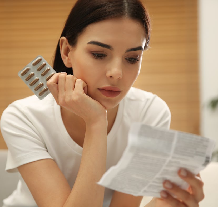 woman looking at pill instructions