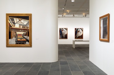 a view of contemporary earth toned paintings hanging on the walls of a museum in Paris