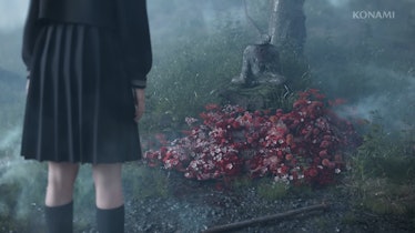 schoolgirl looking at grave of red flowers