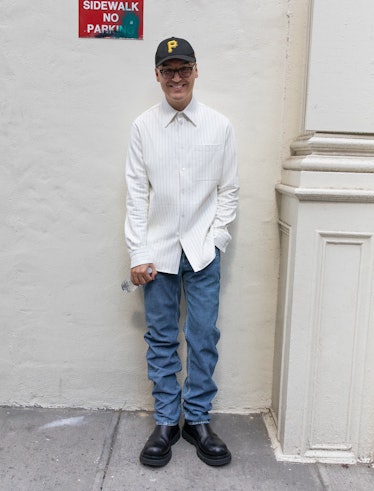 Jimmy Paul wears a Bottega Veneta shirt, pants, and boots; his own cap and glasses.