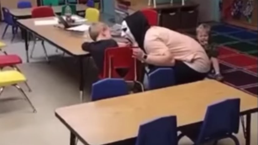 A woman in a mask screams at a child.