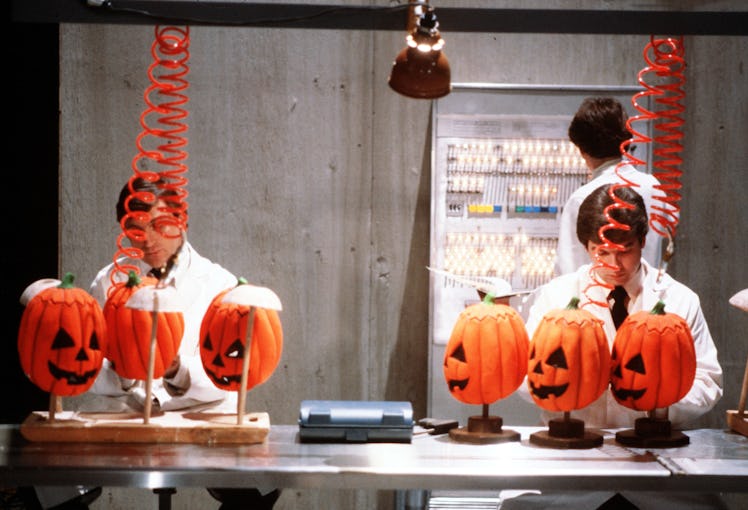Two men in a lab and 6 pumpkin head masks in the movie Halloween III: Season of the Witch