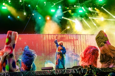 the flaming lips performing on stage with multicolor lights next to nick cave's soundsuits