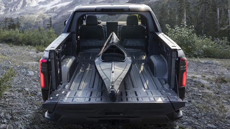 Black Kayak loaded in the trunk of grey Sierra EV Denali in the woods