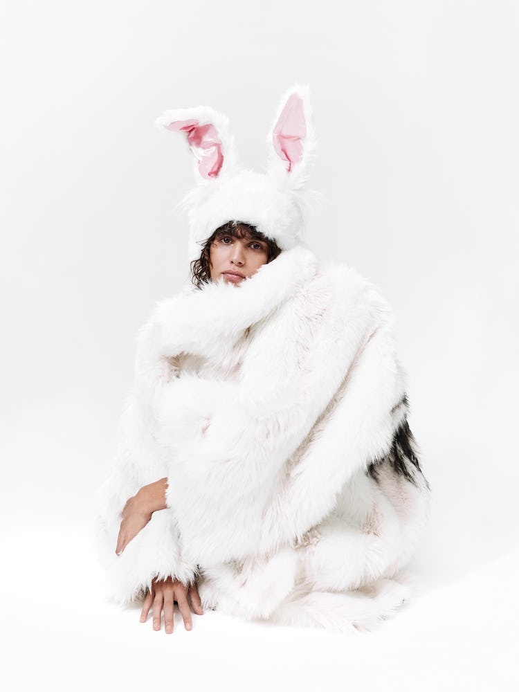 Model wears a white fur coat with bunny ears.
