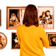 A mom in a yellow sweater looking at the photos of her kids' costumed for Halloween