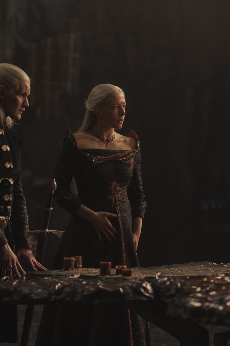 Rhaenyra Targaryen and Daemon Targaryen standing next to each other at a large table