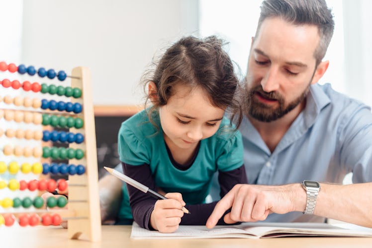 A dad helping his child with math homework using an abacus.