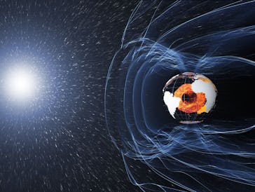 Space image of Earth with magnetic field lines blocking solar radiation