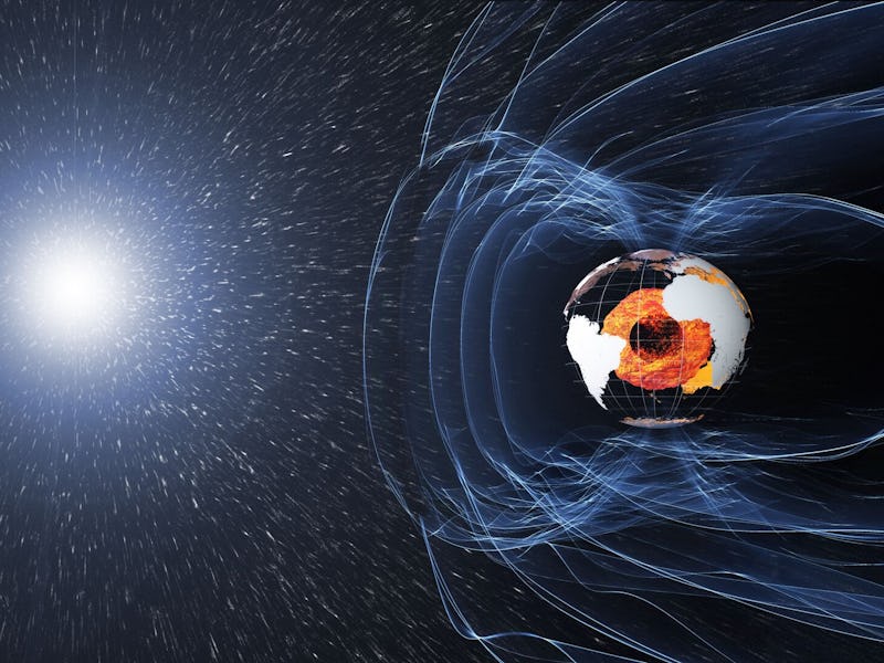 Space image of Earth with magnetic field lines blocking solar radiation