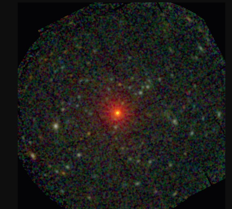 A red-orange  small neutron star at the center of a grainy green and black field