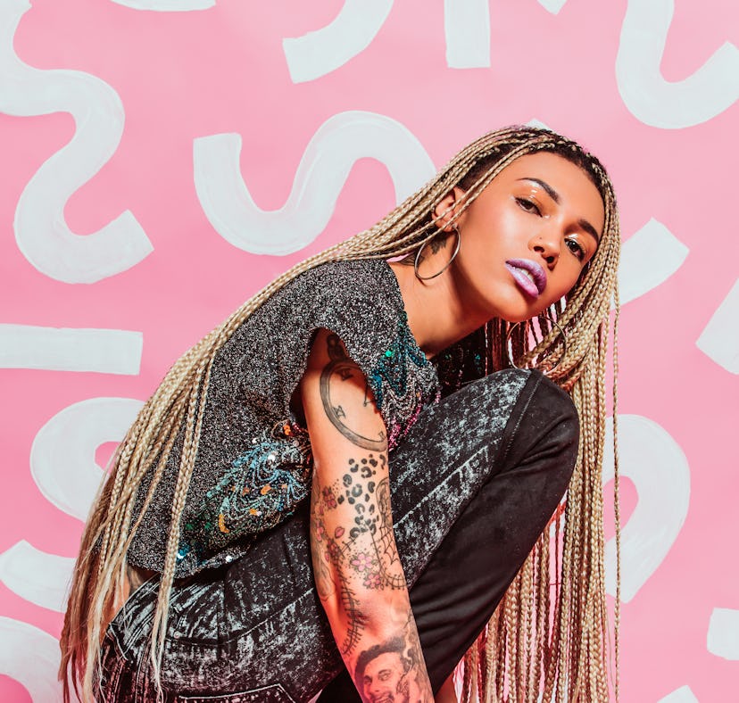 Young woman in front of pink background during Mars retrograde 2022.